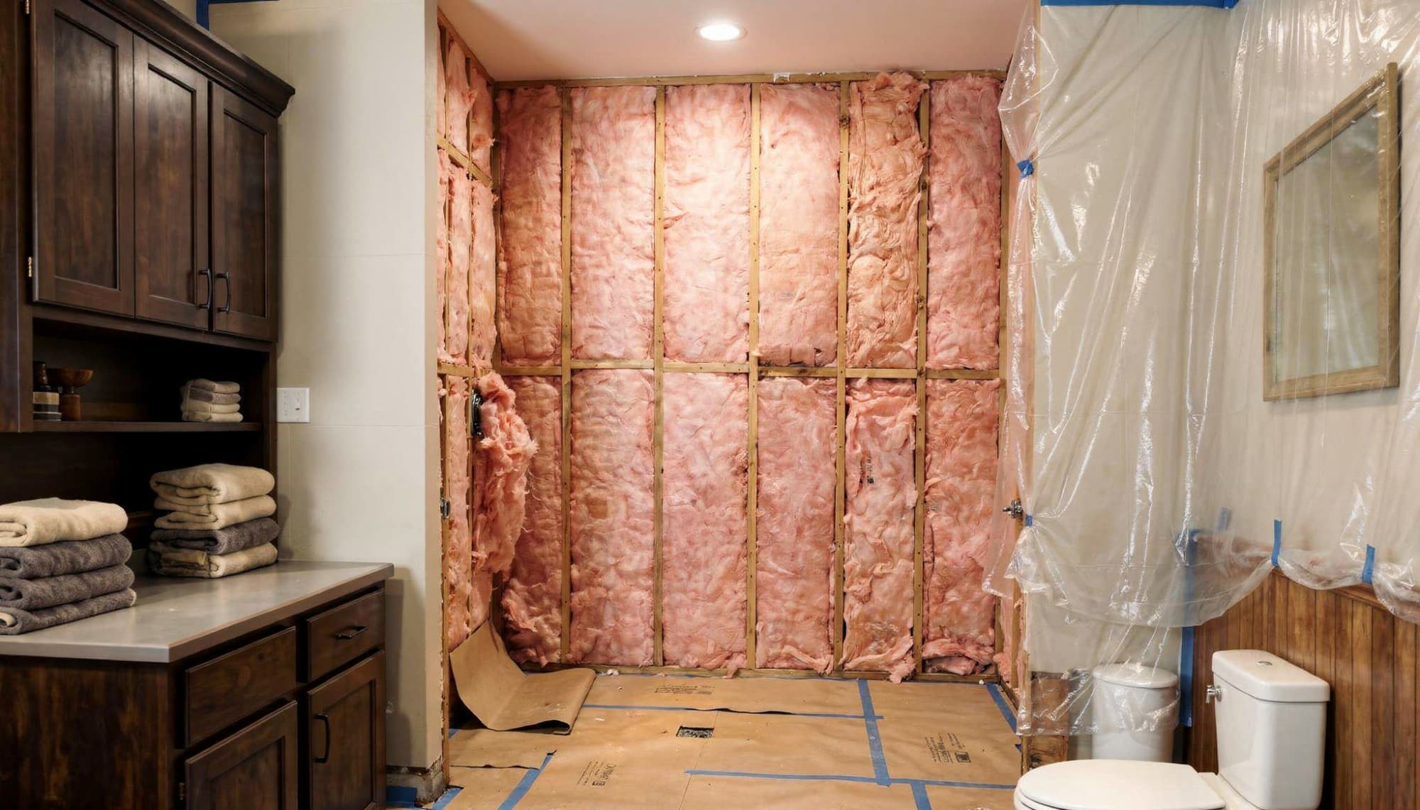 Fresh insulation installed between wall studs during the bathroom remodel